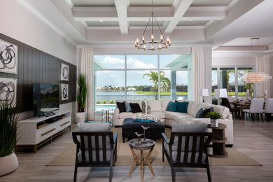 Family room - coastal open concept beige floor family room idea in Miami with white walls, no fireplace and a tv stand