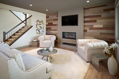 Diseño de sala de estar abierta minimalista con paredes marrones, suelo de madera clara, todas las chimeneas y televisor colgado en la pared