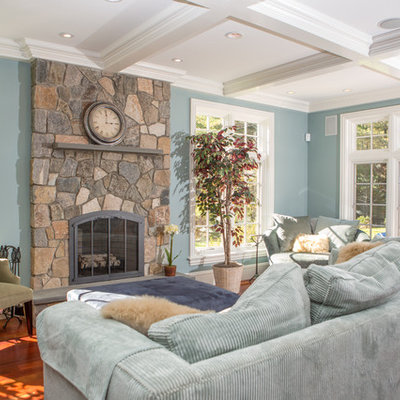 Inspiration for a mid-sized timeless open concept medium tone wood floor and brown floor family room remodel in Boston with blue walls, a standard fireplace, a stone fireplace and no tv