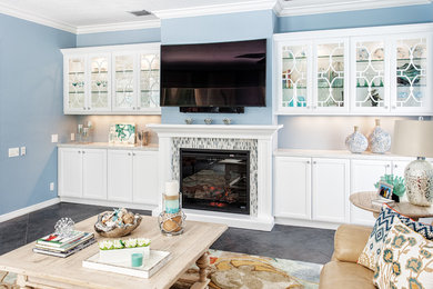 Example of a large beach style open concept slate floor game room design in Miami with blue walls, a standard fireplace, a tile fireplace and a wall-mounted tv