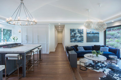 Ejemplo de sala de estar abierta tradicional renovada de tamaño medio con paredes blancas, suelo de madera oscura y pared multimedia