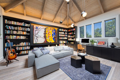 Ejemplo de sala de estar con biblioteca contemporánea grande con paredes blancas, suelo de madera clara y suelo beige