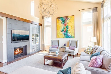 Foto de sala de estar abierta actual con paredes beige, suelo de madera en tonos medios, todas las chimeneas, marco de chimenea de hormigón y televisor colgado en la pared