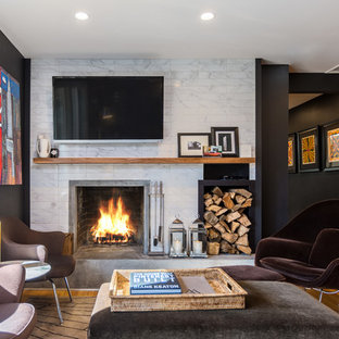 Ejemplo de sala de estar cerrada, clásica renovada, de tamaño medio, con paredes negras, suelo de madera en tonos medios, todas las chimeneas, marco de chimenea de baldosas y/o azulejos, televisor colgado en la pared y suelo marrón