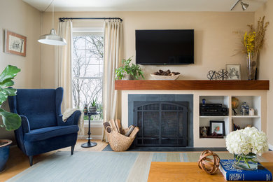Foto de sala de estar clásica renovada de tamaño medio con paredes beige, suelo de madera clara, todas las chimeneas, marco de chimenea de piedra y televisor colgado en la pared