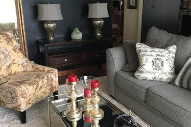 Imagen de sala de estar abierta ecléctica de tamaño medio sin chimenea y televisor con paredes negras, suelo de madera en tonos medios y suelo marrón
