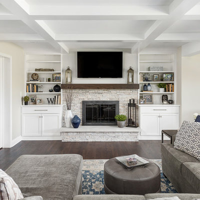 Family room - large transitional open concept dark wood floor and brown floor family room idea in Chicago with beige walls, a standard fireplace, a wall-mounted tv and a stone fireplace