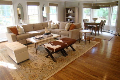 Mid-sized transitional open concept light wood floor family room photo in Boston with beige walls, no fireplace and a concealed tv