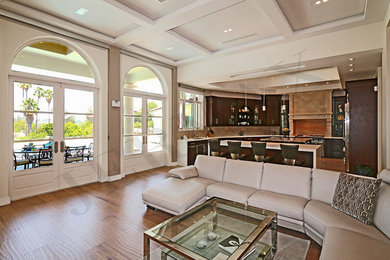 Großes, Offenes Klassisches Wohnzimmer ohne Kamin mit beiger Wandfarbe, braunem Holzboden und braunem Boden in Los Angeles