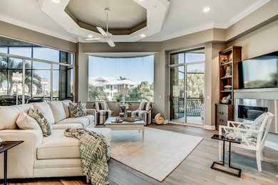 Medium sized classic open plan games room in Miami with beige walls, porcelain flooring, a standard fireplace, a metal fireplace surround and a wall mounted tv.