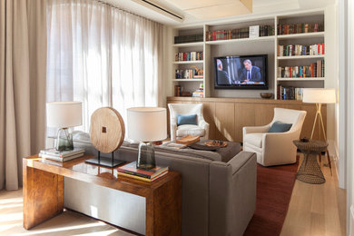 Inspiration for a mid-sized transitional enclosed light wood floor and beige floor family room library remodel in New York with white walls, a wall-mounted tv and no fireplace