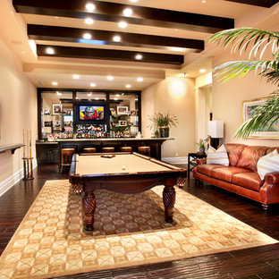 Foto di un grande soggiorno tropicale chiuso con pareti beige, angolo bar, parquet scuro e parete attrezzata