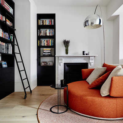 Inspiration for a contemporary light wood floor and beige floor family room remodel with white walls and a standard fireplace