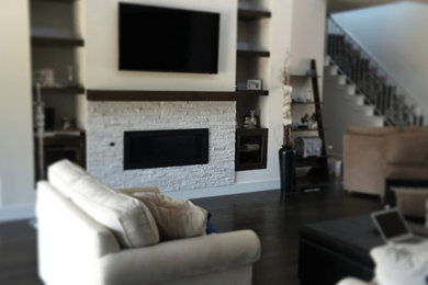 オースティンにある高級なコンテンポラリースタイルのおしゃれなファミリールーム (白い壁、濃色無垢フローリング、標準型暖炉、レンガの暖炉まわり、壁掛け型テレビ、茶色い床) の写真