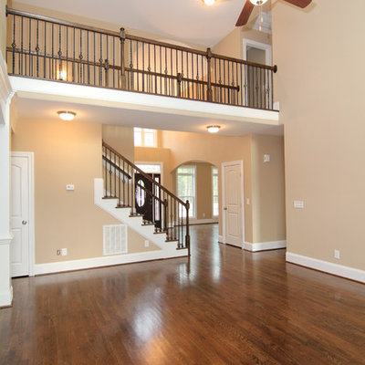 Inspiration for a large timeless open concept dark wood floor family room remodel in Raleigh with beige walls, a standard fireplace, a stone fireplace and a wall-mounted tv