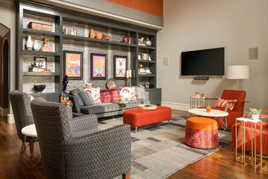 Mid-sized trendy open concept medium tone wood floor and brown floor family room library photo in Dallas with gray walls, a standard fireplace, a wall-mounted tv and a tile fireplace