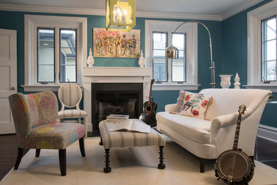 Imagen de sala de estar cerrada clásica renovada de tamaño medio con paredes azules, suelo de madera oscura, todas las chimeneas y marco de chimenea de madera