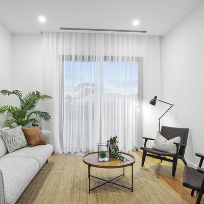 Inspiration for a contemporary enclosed light wood floor and beige floor family room remodel in Geelong with white walls, no fireplace and no tv