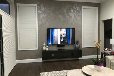 Family room - large transitional open concept dark wood floor family room idea in Miami with gray walls and a wall-mounted tv