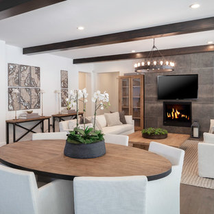 Mittelgroßes, Offenes Landhaus Wohnzimmer mit weißer Wandfarbe, braunem Holzboden, Hängekamin, gefliester Kaminumrandung, Wand-TV und beigem Boden in San Francisco