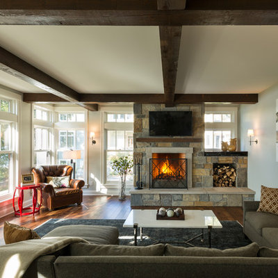 Family room - mid-sized rustic open concept medium tone wood floor and brown floor family room idea in Minneapolis with a standard fireplace, a stone fireplace, a media wall and gray walls