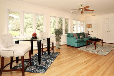Diseño de sala de estar abierta tradicional renovada extra grande sin chimenea con paredes blancas, suelo de madera en tonos medios y televisor colgado en la pared