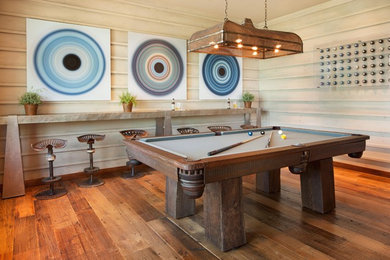 Rustic games room in DC Metro with medium hardwood flooring and no fireplace.