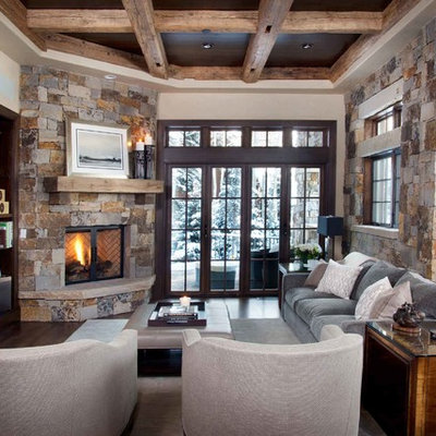 Family room - rustic family room idea in Denver with beige walls, a corner fireplace, a stone fireplace and a wall-mounted tv