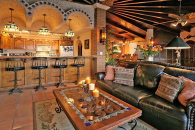 Diseño de sala de estar abierta mediterránea con paredes beige y suelo de baldosas de terracota