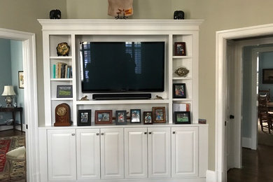 Immagine di un soggiorno chic di medie dimensioni e chiuso con pareti grigie, parquet scuro, TV a parete e pavimento marrone