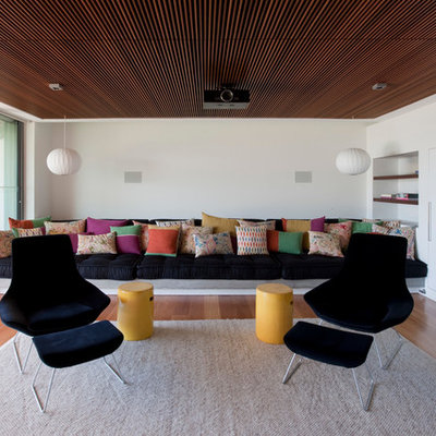 Example of a trendy light wood floor family room design in Sydney with white walls and no fireplace