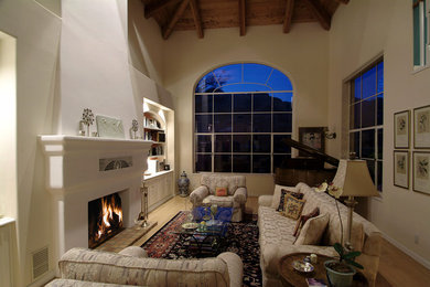 Example of a large tuscan loft-style light wood floor family room design in Phoenix with a music area, beige walls and a standard fireplace
