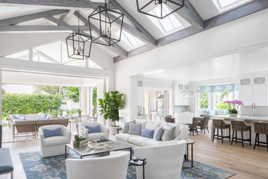 Inspiration for a large coastal open concept light wood floor and beige floor family room remodel in Miami with gray walls, no fireplace and a wall-mounted tv