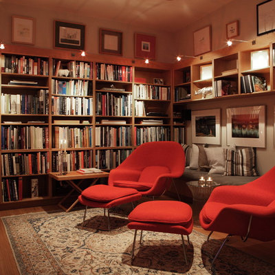 Inspiration for a mid-sized contemporary enclosed medium tone wood floor and brown floor family room library remodel in Austin with a wall-mounted tv, beige walls and no fireplace