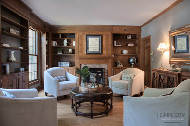 Family room library - mid-sized transitional light wood floor family room library idea in New York with gray walls, a standard fireplace and a brick fireplace