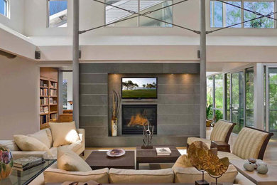 Modelo de sala de estar contemporánea con paredes blancas, suelo de madera clara, todas las chimeneas, marco de chimenea de baldosas y/o azulejos y pared multimedia