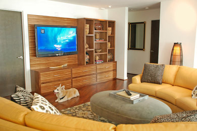 Example of a trendy medium tone wood floor family room design in Seattle with white walls and a wall-mounted tv