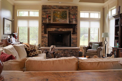 Diseño de sala de estar abierta tradicional renovada grande con suelo de madera en tonos medios, todas las chimeneas y marco de chimenea de piedra