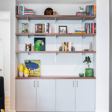 Walnut Shelves Above Grey Storage Cabinets in the Family Room