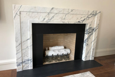Diseño de sala de estar clásica renovada con marco de chimenea de piedra