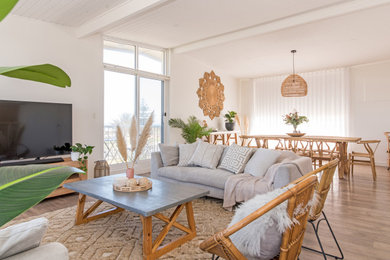 Diseño de sala de estar costera con paredes blancas y suelo laminado