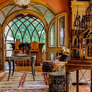 Klassisches Wohnzimmer mit oranger Wandfarbe und braunem Holzboden in Atlanta