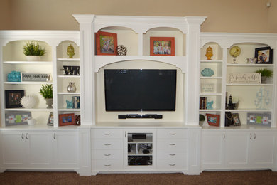 Diseño de sala de estar cerrada clásica de tamaño medio sin chimenea con paredes beige, moqueta, televisor colgado en la pared y suelo beige