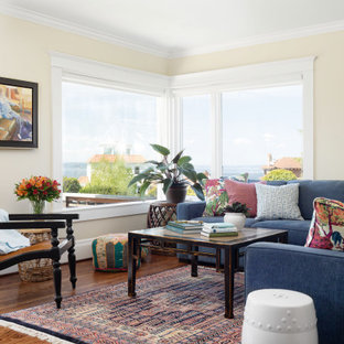Kleines, Fernseherloses, Offenes Stilmix Wohnzimmer ohne Kamin mit gelber Wandfarbe, braunem Holzboden und braunem Boden in Seattle