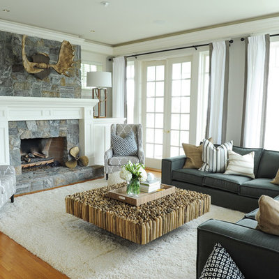 Family room - large coastal open concept medium tone wood floor and brown floor family room idea in Vancouver with a standard fireplace, a stone fireplace, gray walls and a wall-mounted tv