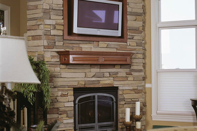 Design ideas for a medium sized classic enclosed games room in Minneapolis with beige walls, medium hardwood flooring, a standard fireplace, a stone fireplace surround and a wall mounted tv.