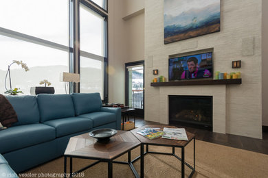 Modelo de sala de estar tipo loft minimalista grande con paredes beige, suelo de madera oscura, todas las chimeneas, marco de chimenea de yeso y pared multimedia