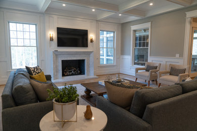 Inspiration for a mid-sized transitional enclosed light wood floor and brown floor family room remodel in DC Metro with gray walls, a standard fireplace, a stone fireplace and a wall-mounted tv