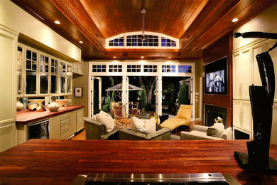 Diseño de sala de estar abierta clásica renovada grande con paredes beige, suelo de madera en tonos medios, todas las chimeneas, marco de chimenea de yeso y televisor colgado en la pared