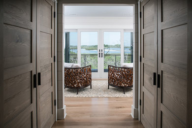 Diseño de sala de estar cerrada contemporánea de tamaño medio sin chimenea y televisor con paredes blancas, suelo de madera clara y suelo marrón